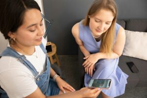 https://unsplash.com/photos/two-women-sitting-on-a-couch-looking-at-a-cell-phone-Xh0xRT90i4Q